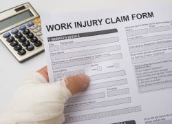hurted hand holding a work injury claim form